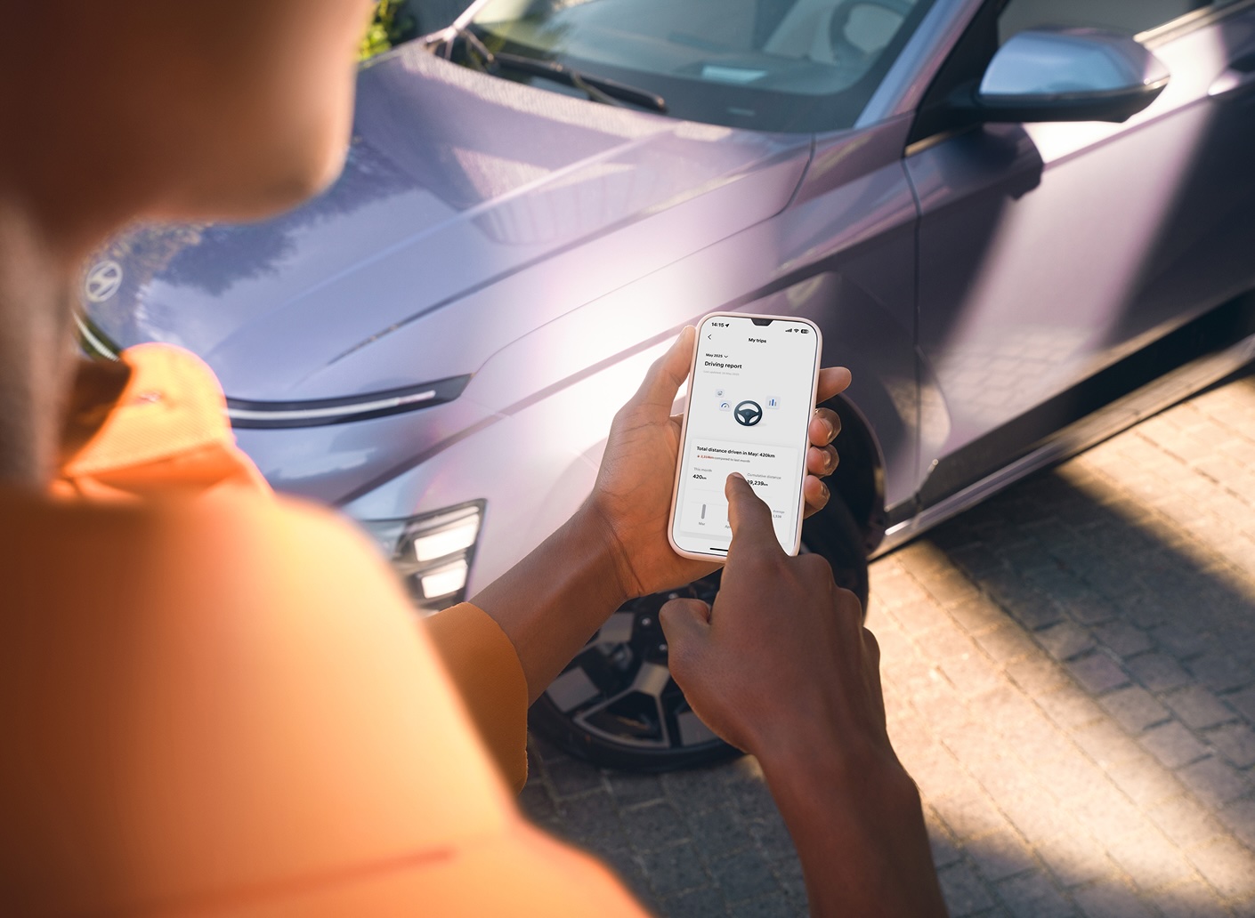 Hyundai Bluelink: a myHyundai app a telefonon egy Hyundai KONA Electric mellett